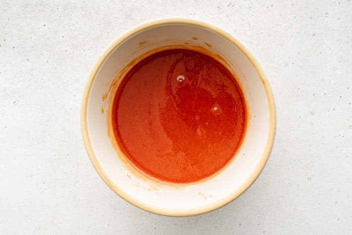 Whisked French dressing in a mixing bowl.