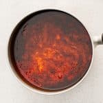 Sauce bubbling with fiery red undertones as it cooks down and thickens, infusing all the flavors together.