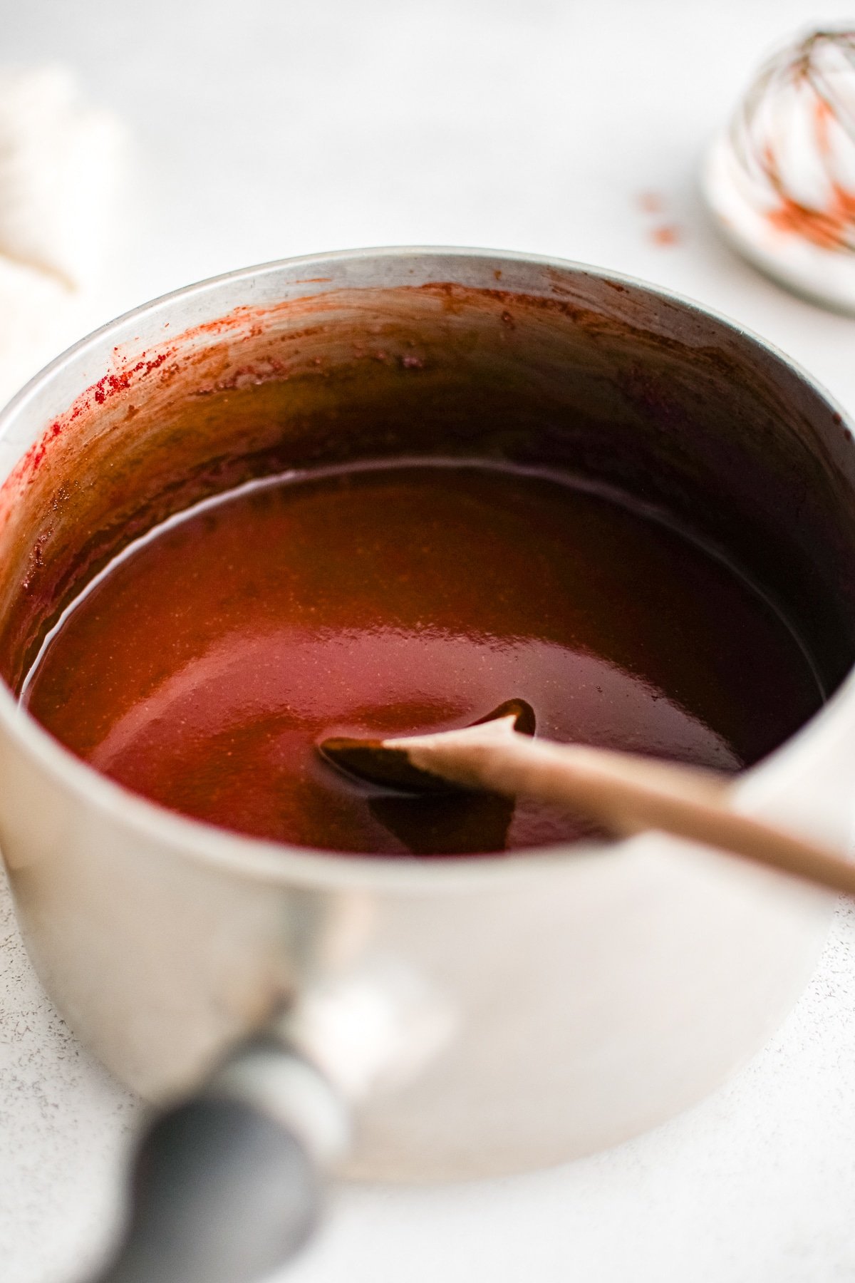 Mumbo sauce with a wooden spoon resting in the pot