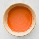 Smooth, fully mixed spicy mayo in a beige bowl.