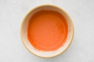 Smooth, fully mixed spicy mayo in a beige bowl.