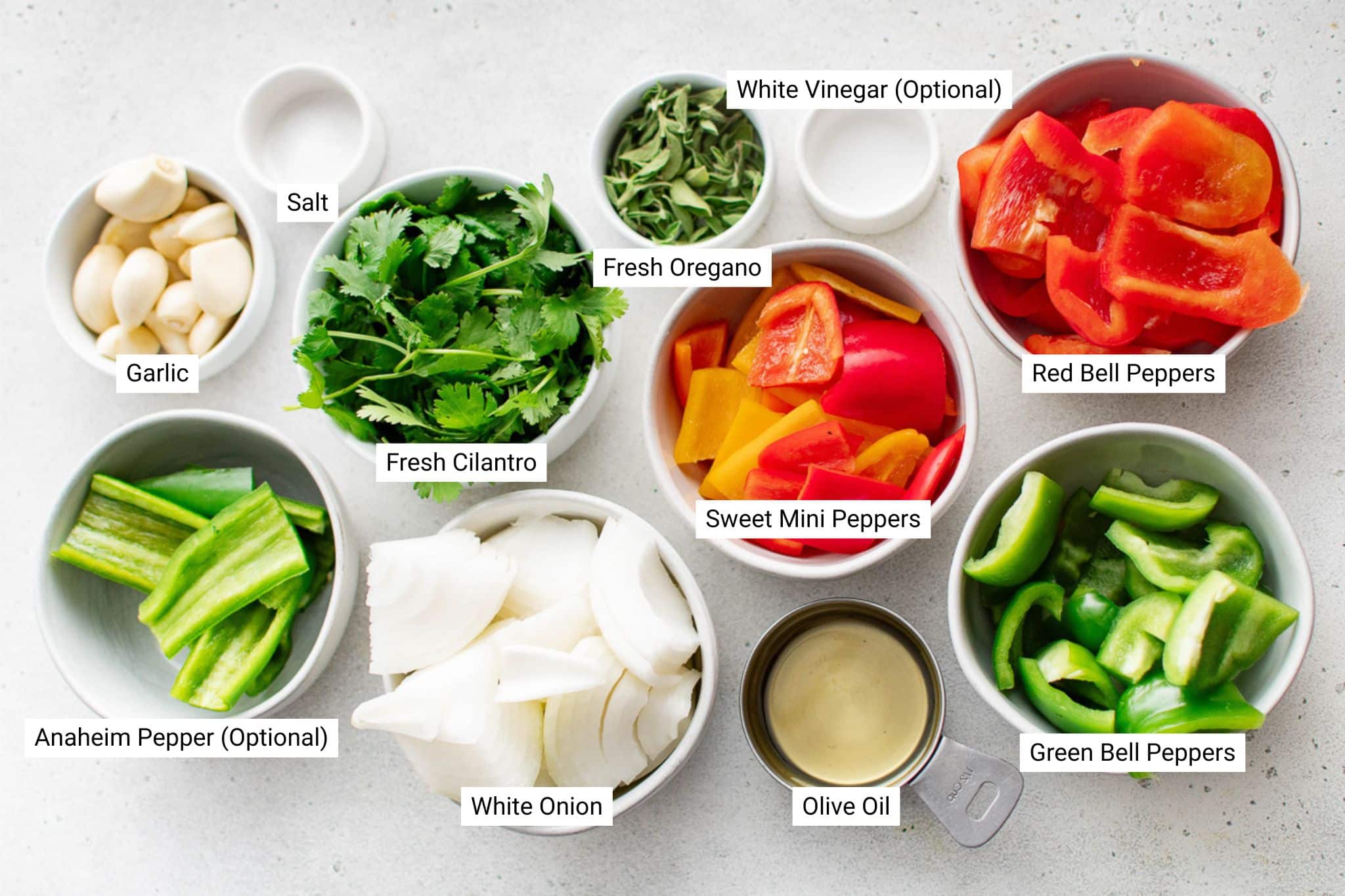 Labeled sofrito ingredients including garlic, cilantro, peppers, onion, and oregano arranged in small bowls