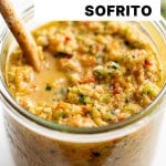 Close-up of jar filled with sofrito and wooden spoon, text overlay reads โVegan & Gluten-Free Puerto Rican-Style Homemade Sofritoโ