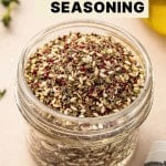 Glass jar filled with za’atar spice blend on a neutral countertop with olive oil in the background and text overlay saying "Homemade Za'atar Seasoning"