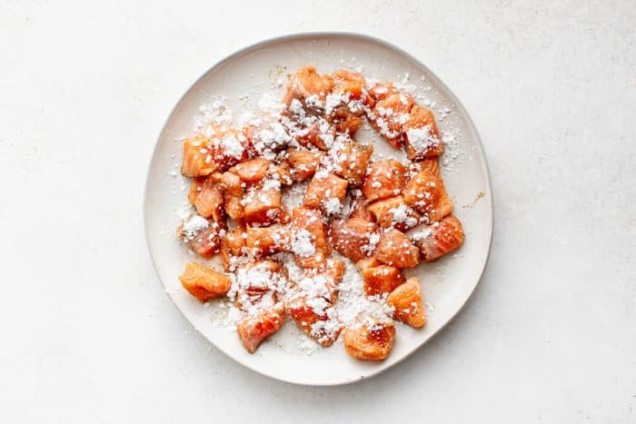 Salmon cubes sprinkled with cornstarch to create a crispy coating.