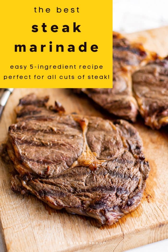 A Pinterest pin highlighting grilled steak made with the best marinade recipe. The image shows a close-up of two seared steaks resting on a wooden cutting board, their browned crust glistening with juices. The top has a bright yellow overlay with bold black text reading: “The Best Steak Marinade – Easy 5-Ingredient Recipe Perfect for All Cuts of Steak!” The bottom includes branding text: “The Forked Spoon.”