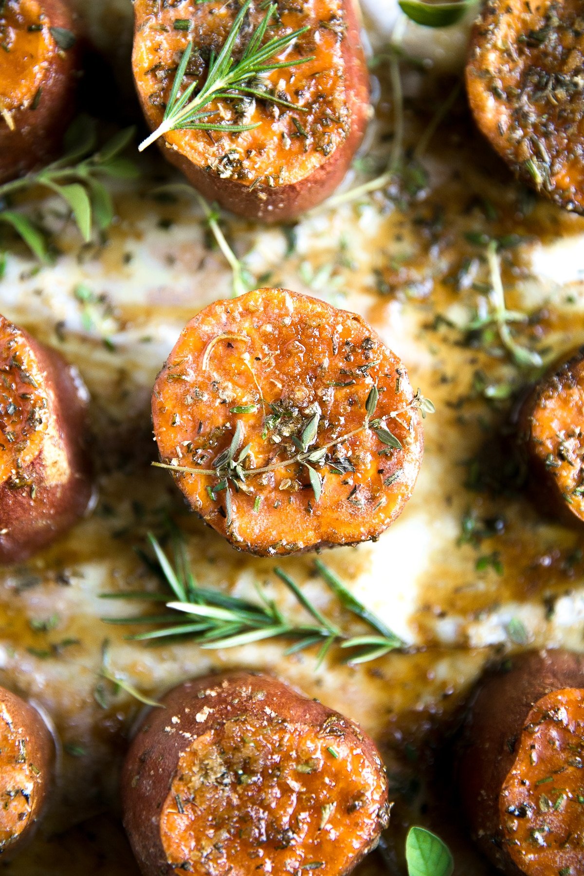 Roasted sweet potato rounds topped with fresh herbs and melted butter.