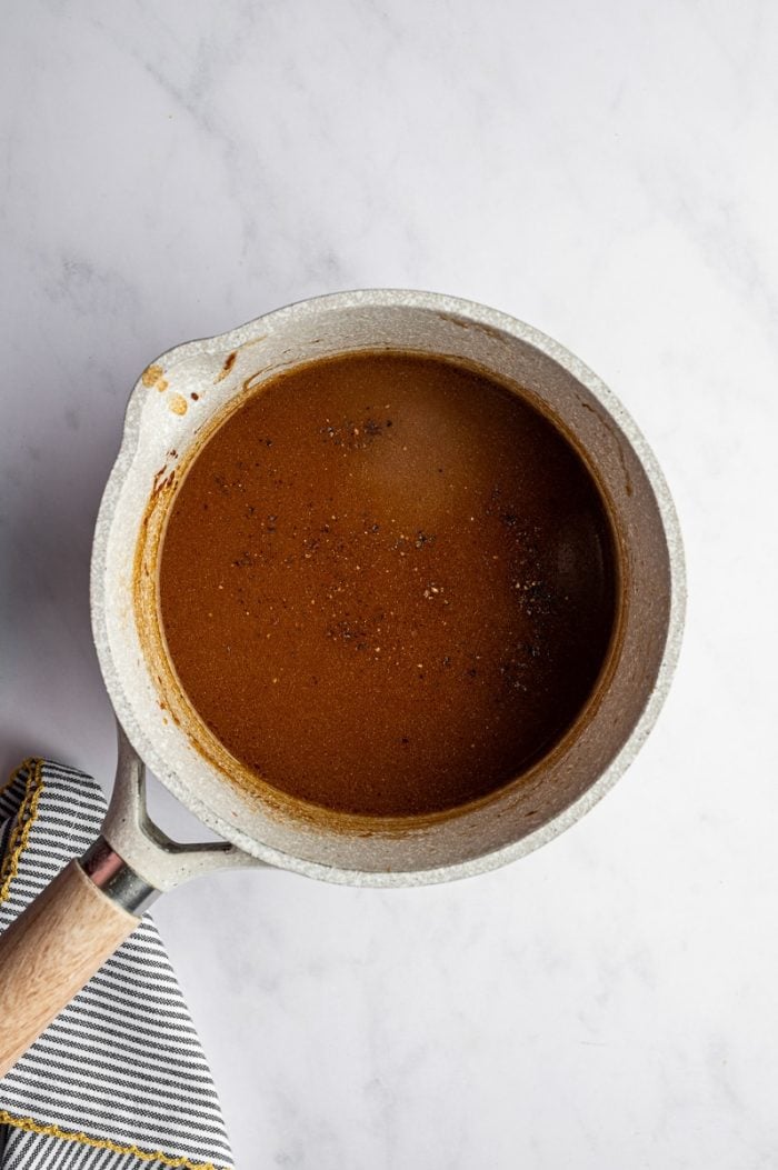 Homemade turkey gravy made from drippings in a saucepan for an easy Thanksgiving turkey recipe