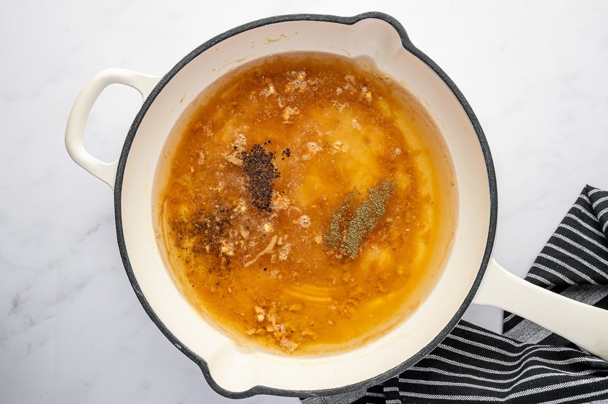 Broth and seasonings added to roux in a skillet while making gravy without drippings.