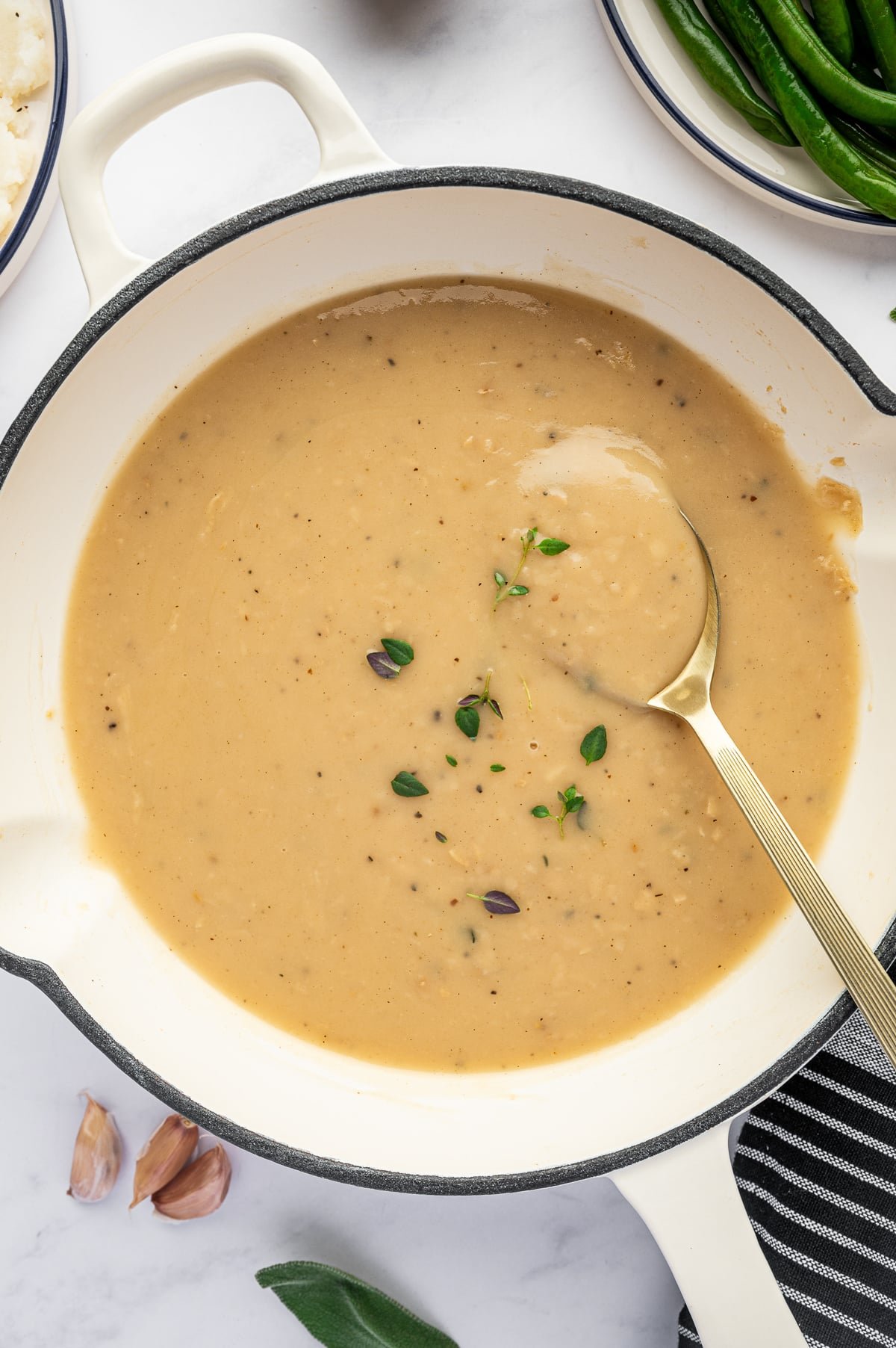 Creamy homemade gravy with fresh herbs in a skillet ready to serve.