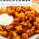 Pinterest pin image with text overlay that reads “AIR FRYER BUFFALO CAULIFLOWER” and “delicious game day snack!” above a photo of crispy buffalo cauliflower bites on a white plate with ranch dip, celery sticks, and a bowl of buffalo sauce, plus “the forked spoon” branding at the bottom.
