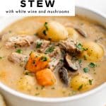 Pinterest pin showing a close-up of creamy one-pot pork stew in a white bowl, filled with baby potatoes, carrot chunks, sliced mushrooms, and tender pork pieces, sprinkled with chopped green herbs. A large white text box at the top left reads โONE-POT PORK STEWโ with the subtitle โwith white wine and mushrooms.โ Bread is partially visible along the left edge, and โtheforkedspoon.comโ appears as a small watermark at the bottom.