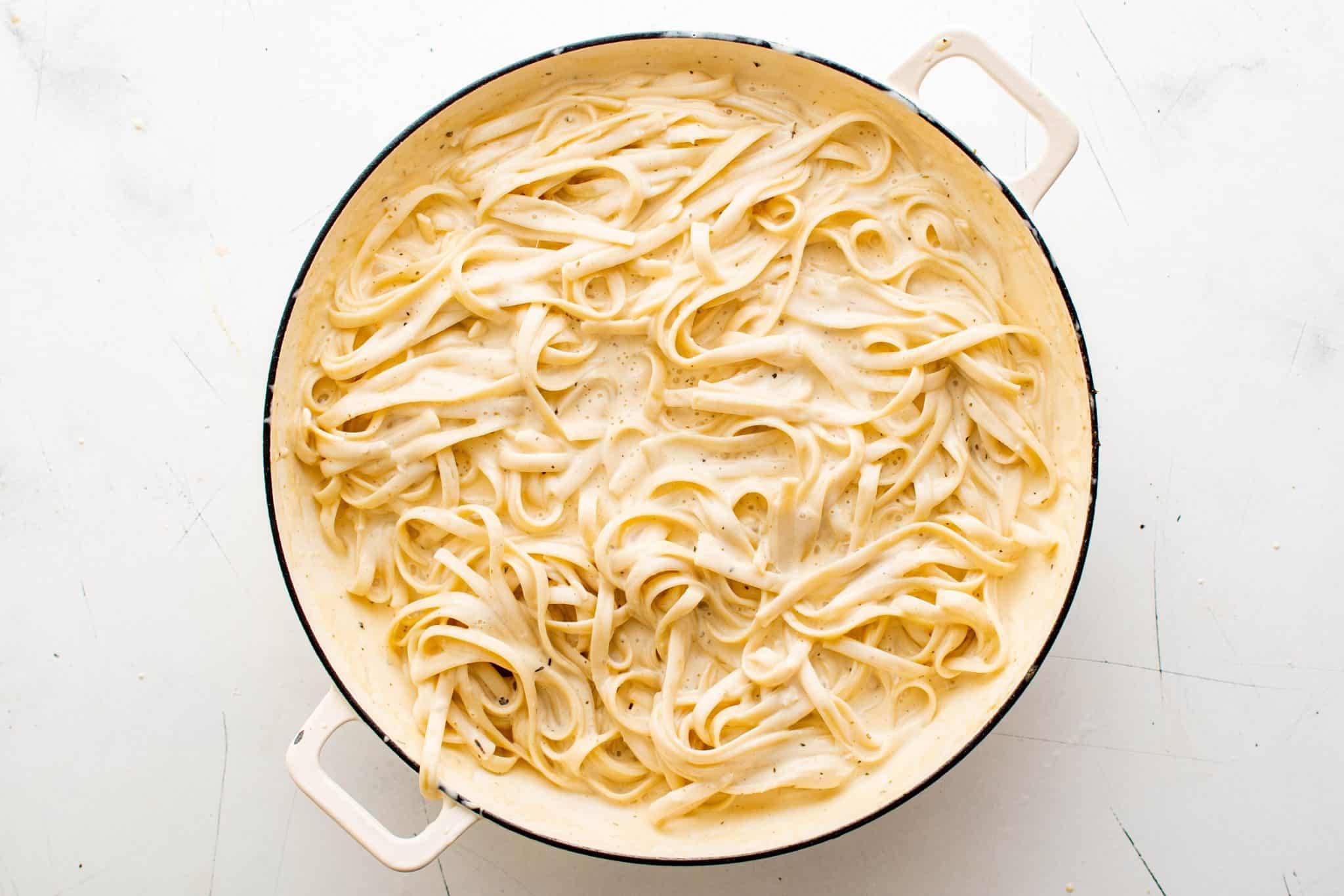Cook fettuccine pasta and homemade Alfredo sauce in a large skillet.