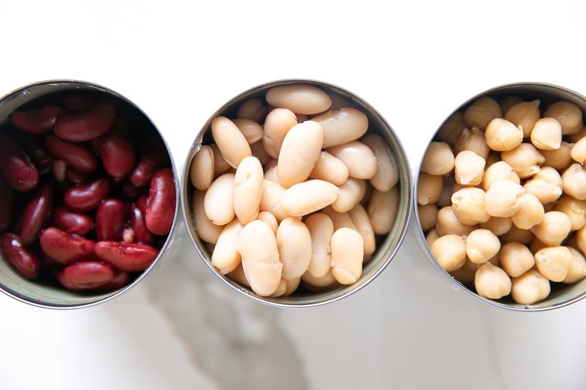 Overhead image of three open cans of beans.