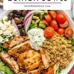 Pinterest pin image of Greek chicken quinoa bowls with sliced golden chicken, cooked quinoa, cherry tomatoes, cucumber, Kalamata olives, red onion, feta, arugula, and tzatziki, with a white text overlay that reads โGREEK CHICKEN QUINOA BOWLSโ and โTHEFORKEDSPOON.COM.โ