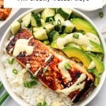 Pinterest pin image of a teriyaki salmon bowl with rice, broiled salmon, cucumber, avocado, sesame seeds, green onion, and creamy wasabi mayo, with a white text box overlay reading "Teriyaki Salmon Bowl" and "with creamy wasabi mayo."
