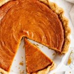 Overhead image of a sweet potato pie with one slice removed.